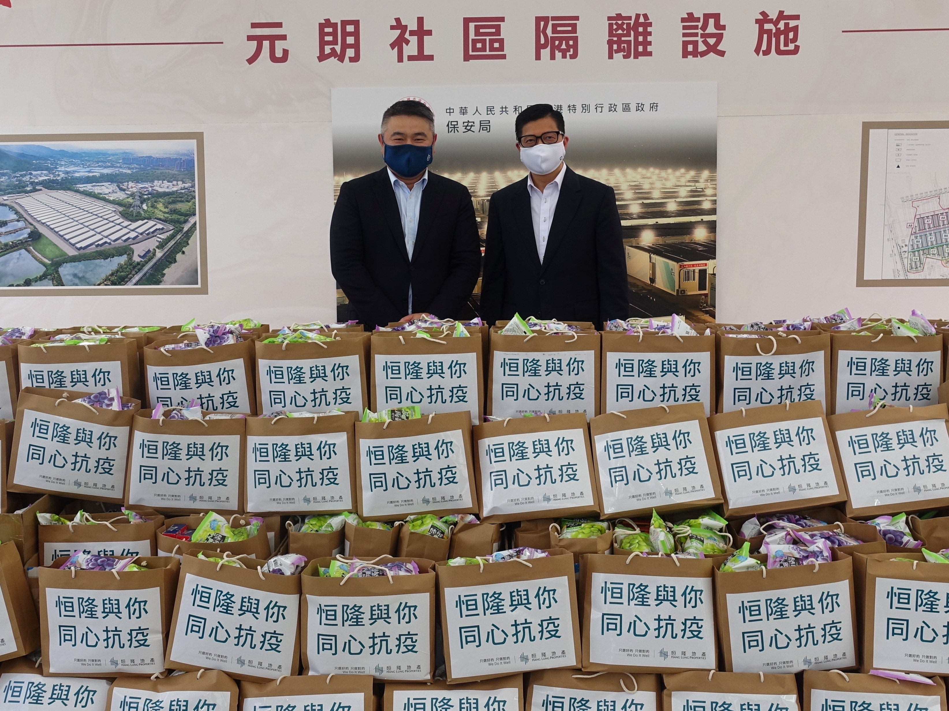 (From left) Mr. Weber Lo, Chief Executive Officer of Hang Lung Properties, presents Anti-Pandemic Care Packs including surgical masks, rapid antigen testing kits, health supplements and snacks, to Mr. Tang Ping-keung, PDSM, JP, Secretary for Security of the HKSAR Government at the mobile cabin hospital in Tam Mei, Yuen Long