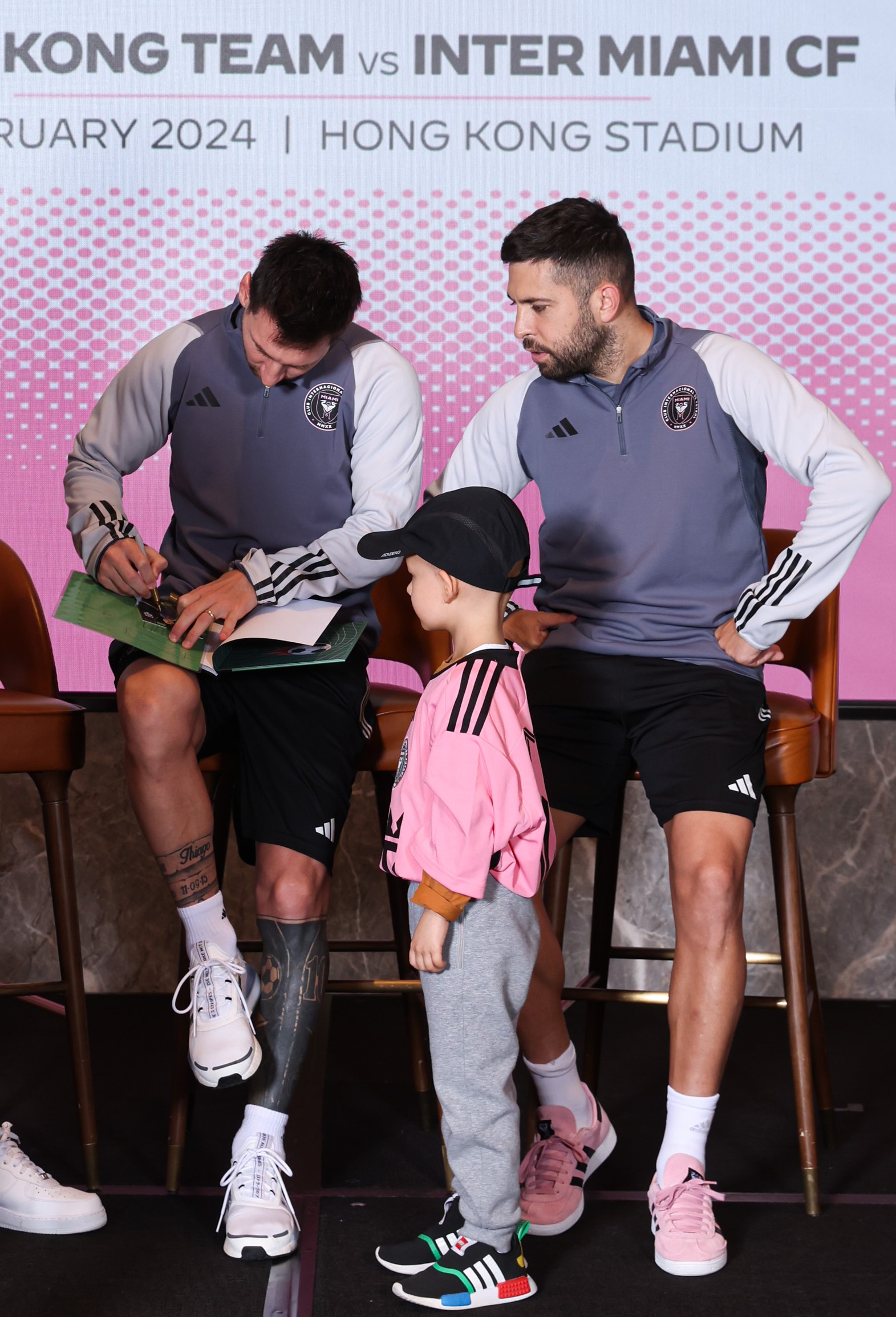 Messi presents a signed photograph to a wish kid.