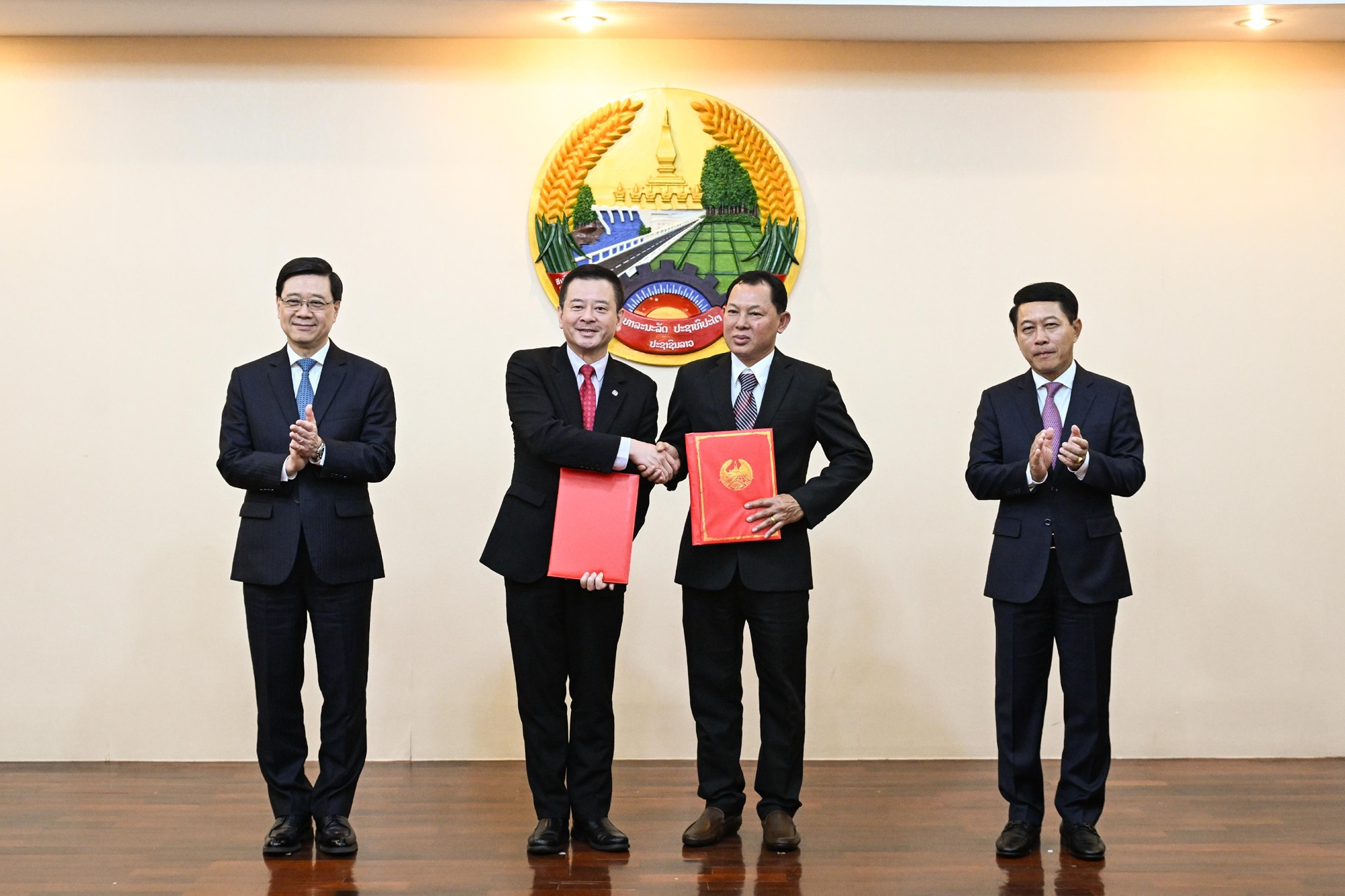 John Lee, Chief Executive of the HKSAR (first left) and Saleumxay Kommasith, Lao Deputy Prime Minister and Minister of Foreign Affairs (first right), witness the signing of MoU between PolyU and VSS on July 29.