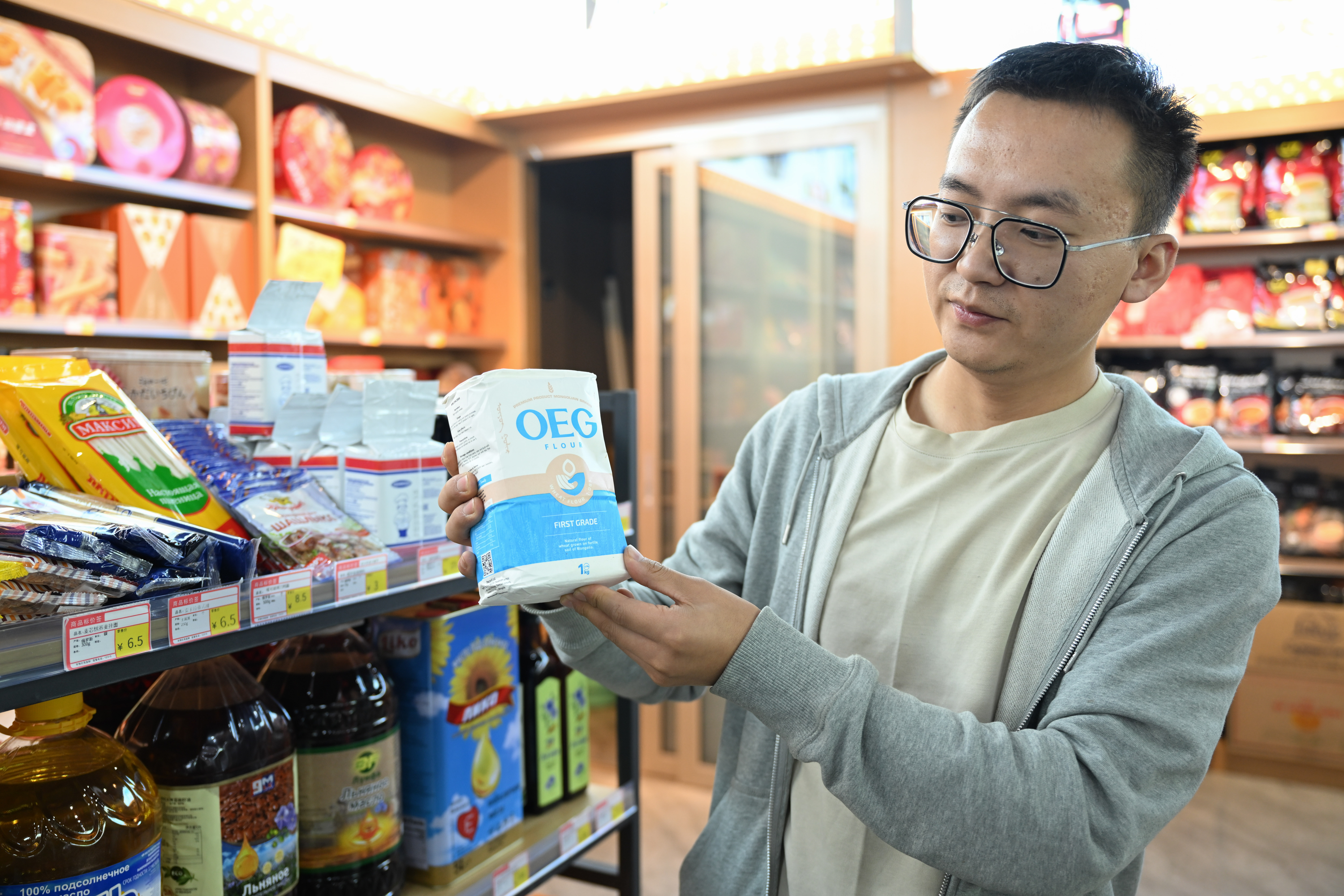 A shop owner displays a Mongolian flour product at an import supermarket in Erenhot, north China's Inner Mongolia Autonomous Region, Sept. 11, 2024.