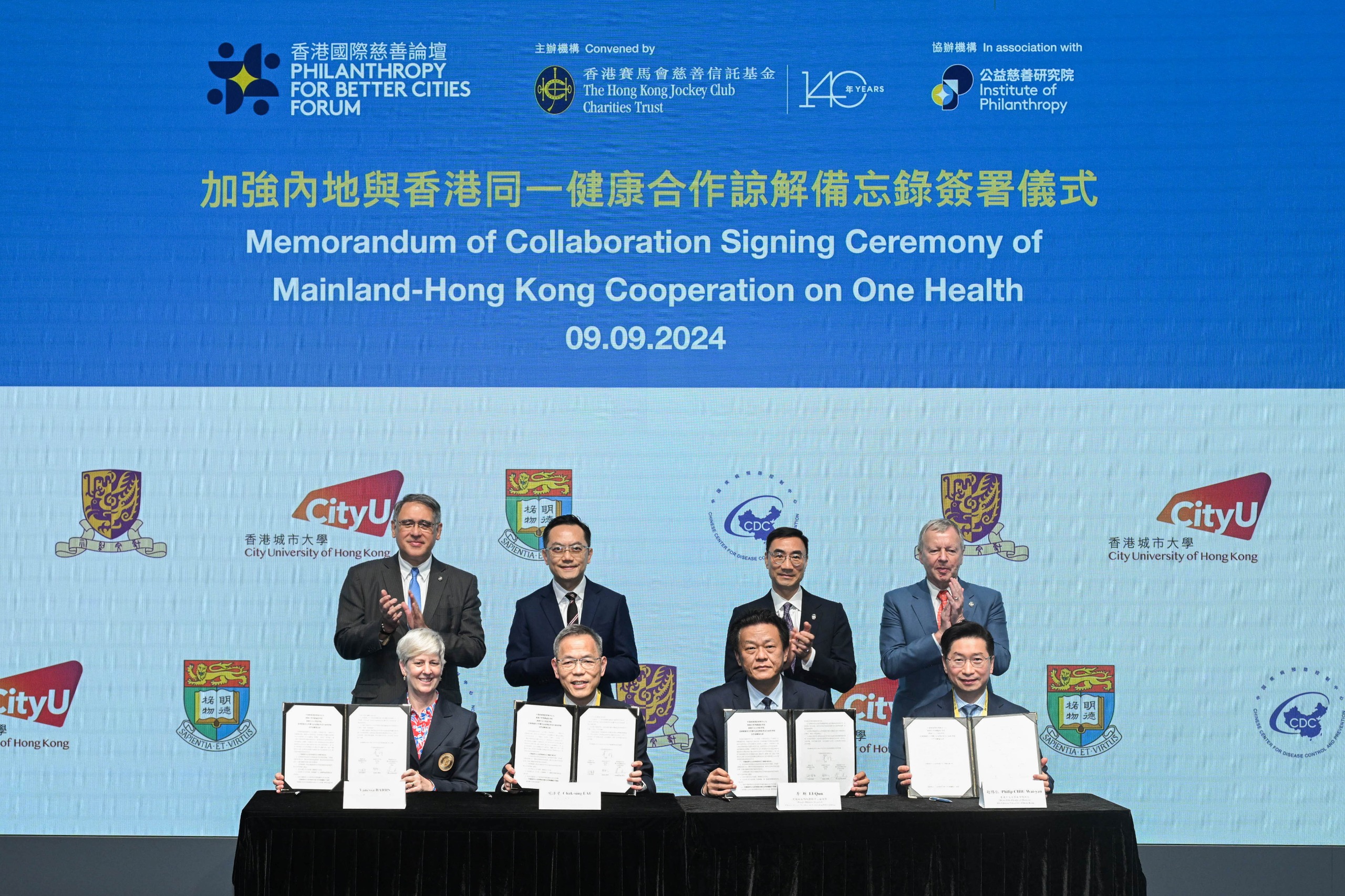 The Memorandum of Collaboration was signed by Li Qun, Deputy Director General, Chinese Center for Disease Control and Prevention (front row, 2nd right); Prof Chak-sing Lau, Dean of Medicine, The University of Hong Kong (front row, 2nd left); Prof Philip Chiu Wai-yan, Dean of Medicine, The Chinese University of Hong Kong (front row, 1st right); and Prof Vanessa Barrs, Dean, Jockey Club College of Veterinary Medicine and Life Sciences, City University of Hong Kong (front row, 1st left). The signing ceremony was witnessed by Michael Lee, Chairman of The Hong Kong Jockey Club (back row, 2nd right); Lester Huang, Chairman of IoP and Steward of The Hong Kong Jockey Club (back row, 1st left); Winfried Engelbrecht- Bresges, CEO of The Hong Kong Jockey Club and Director of IoP (back row, 1st right); and Dr Ronald Lam, Director of Health, HKSAR Government (back row, 2nd left).