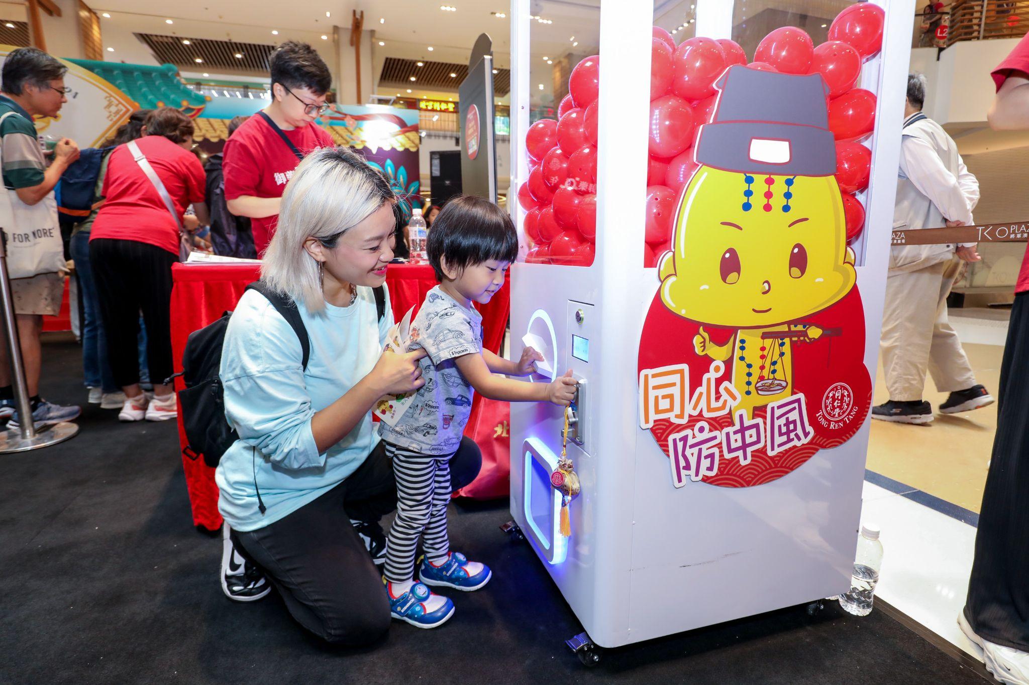 Image 3: Citizens learn while having fun, playing "Health Capsule Prize Draw" in the Health Maze and learning various stroke prevention tips. Caption