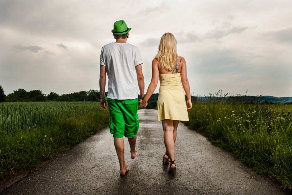 Young couple walking hand in hand in rural landscape